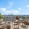 chairs and wicker tables on rooftop patio with city and water views